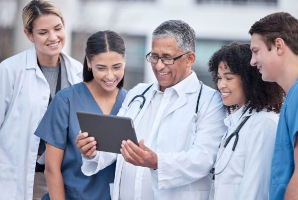 Unity Insurance | A MedChi Company - Group of Doctors Looking Over a Tablet Together